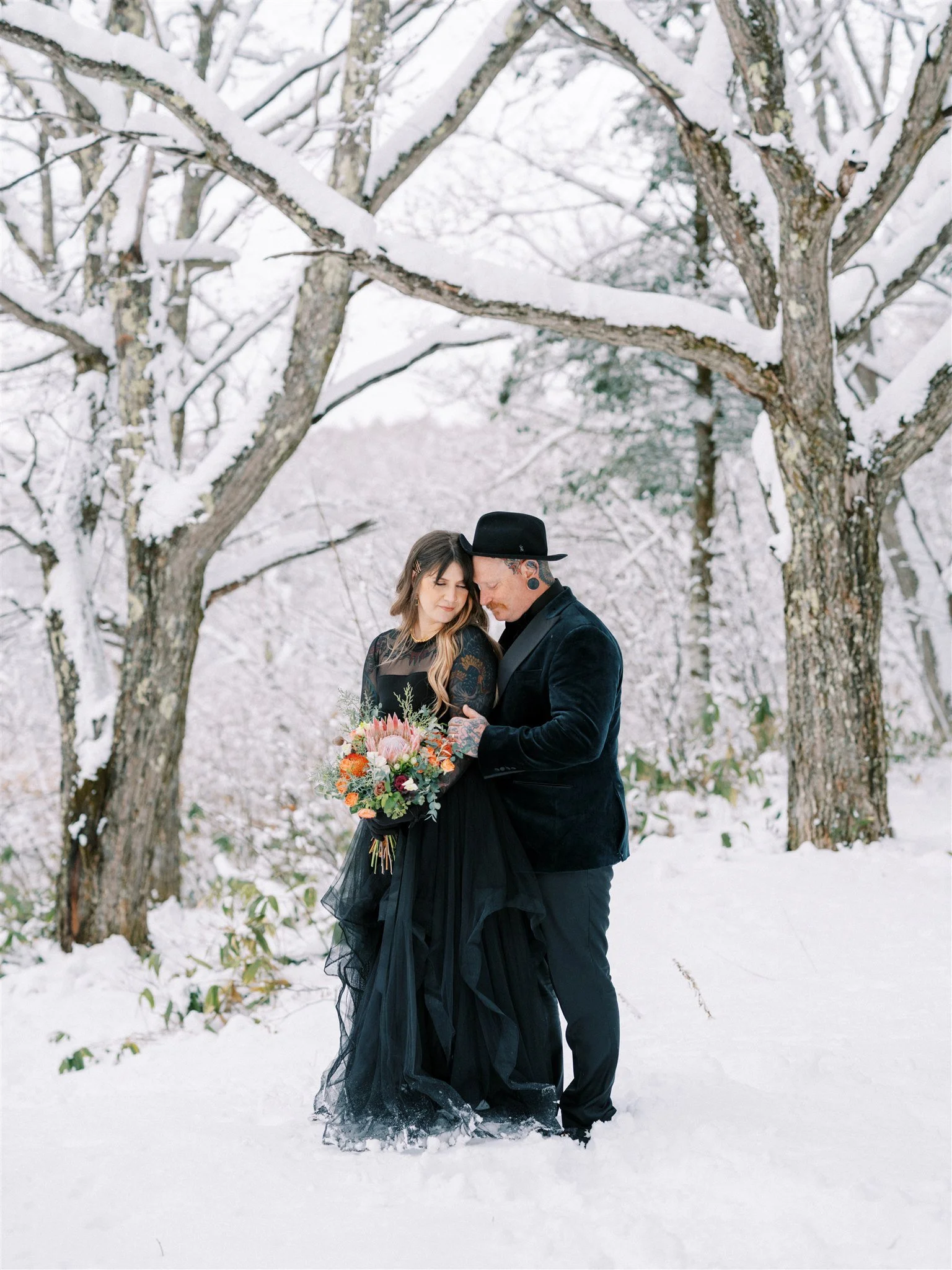 Couple portrait in snowy Nagano forest during elopement