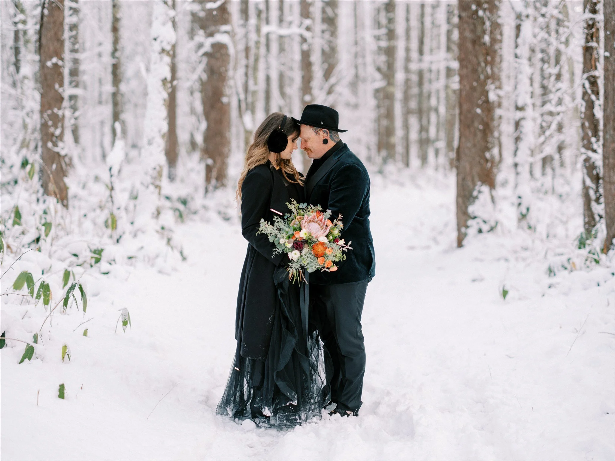 Couple portrait in snowy Nagano forest during elopement