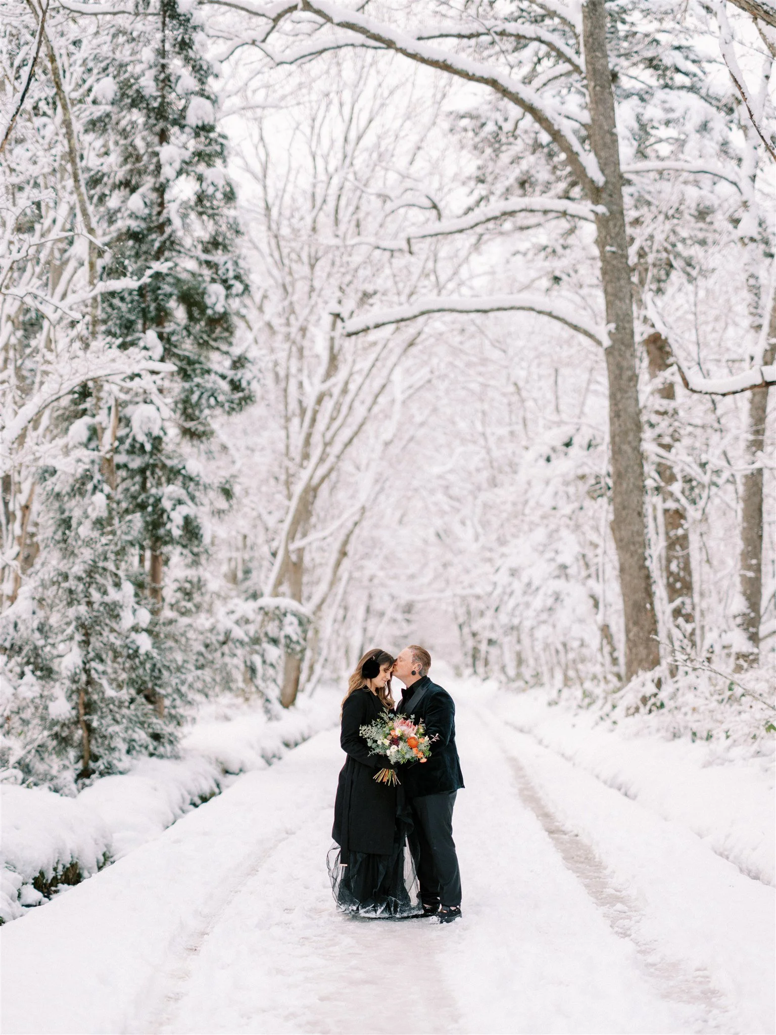 Couple portrait in snowy Nagano forest during elopement