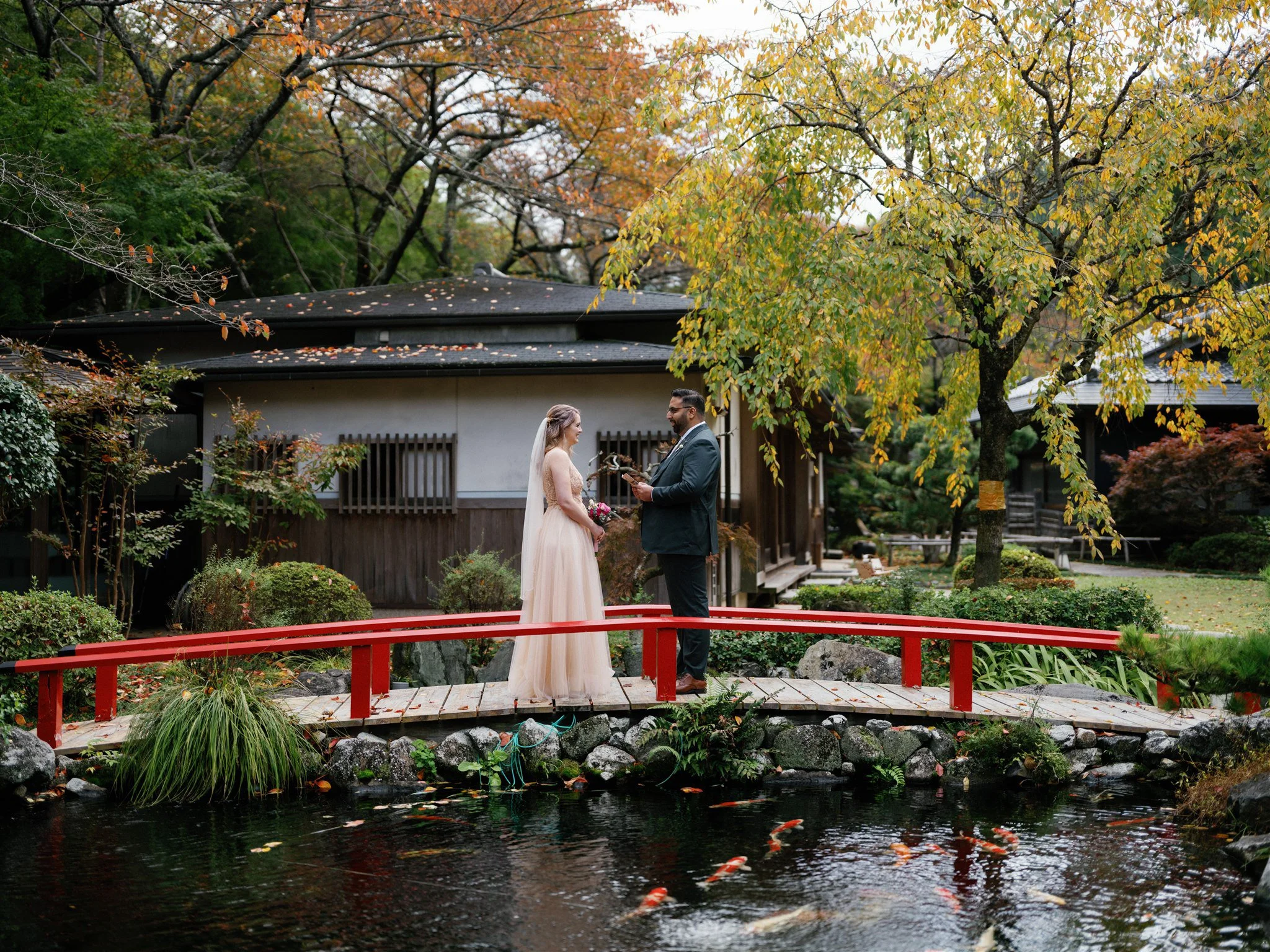  couple exchanging vows beside koi pond in Japan 