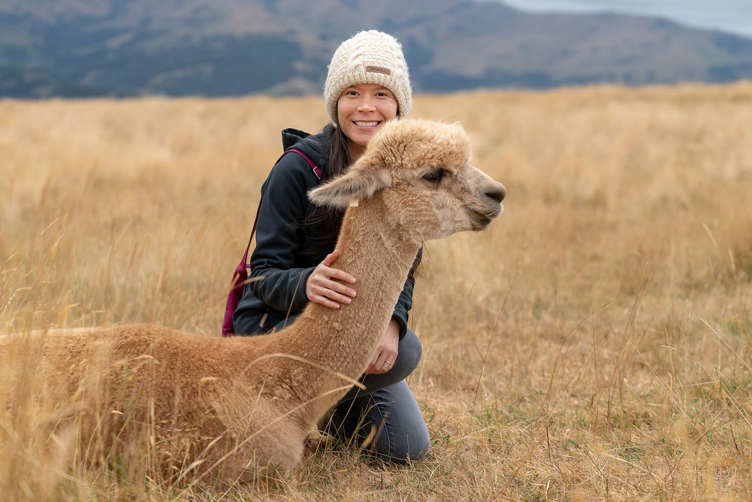 Thaneeya McArdle with an alpaca at Shamarra Alpaca Farm in Akaroa, New Zealand
