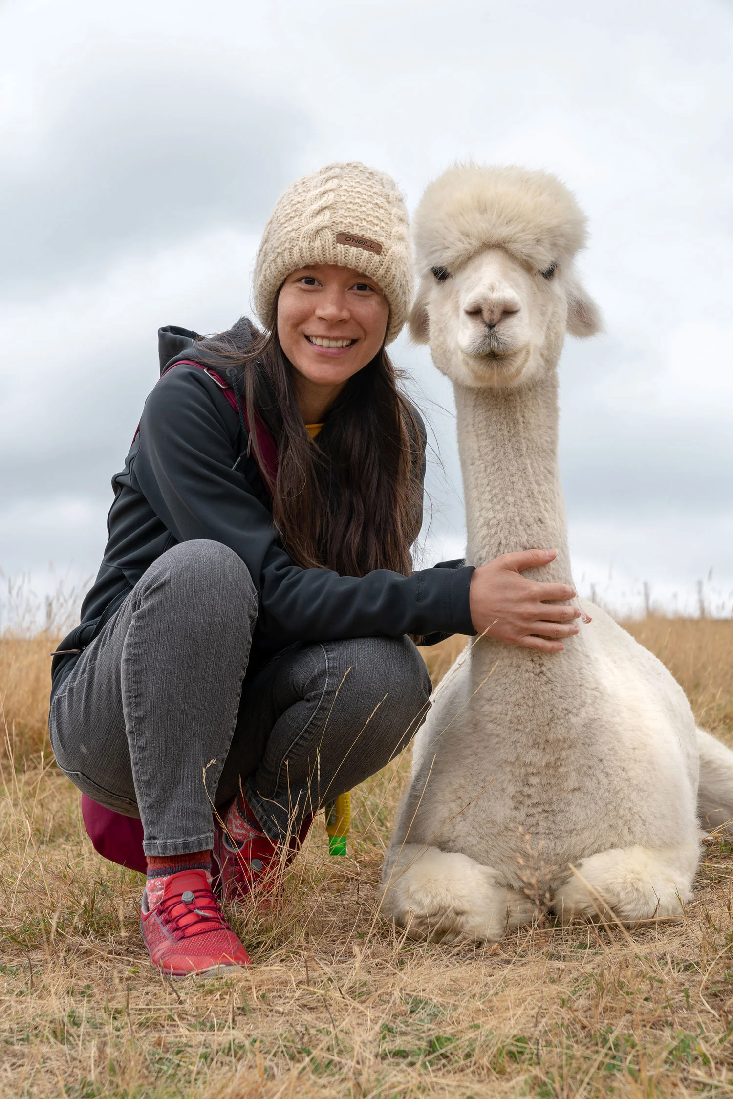 Thaneeya McArdle with an alpaca at Shamarra Alpaca Farm in Akaroa, New Zealand