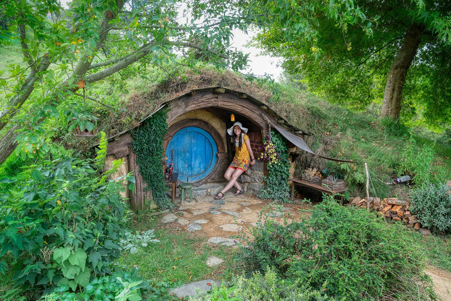 Thaneeya McArdle in front of a Hobbit home in Hobbiton