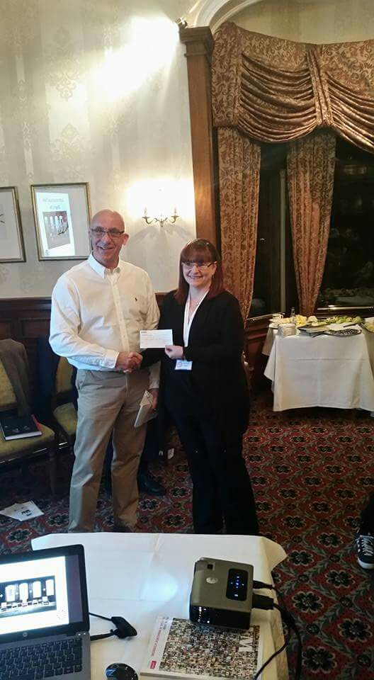 Liza Quin being presented the cheque by one of the Dragons, Alan Johnstone . 