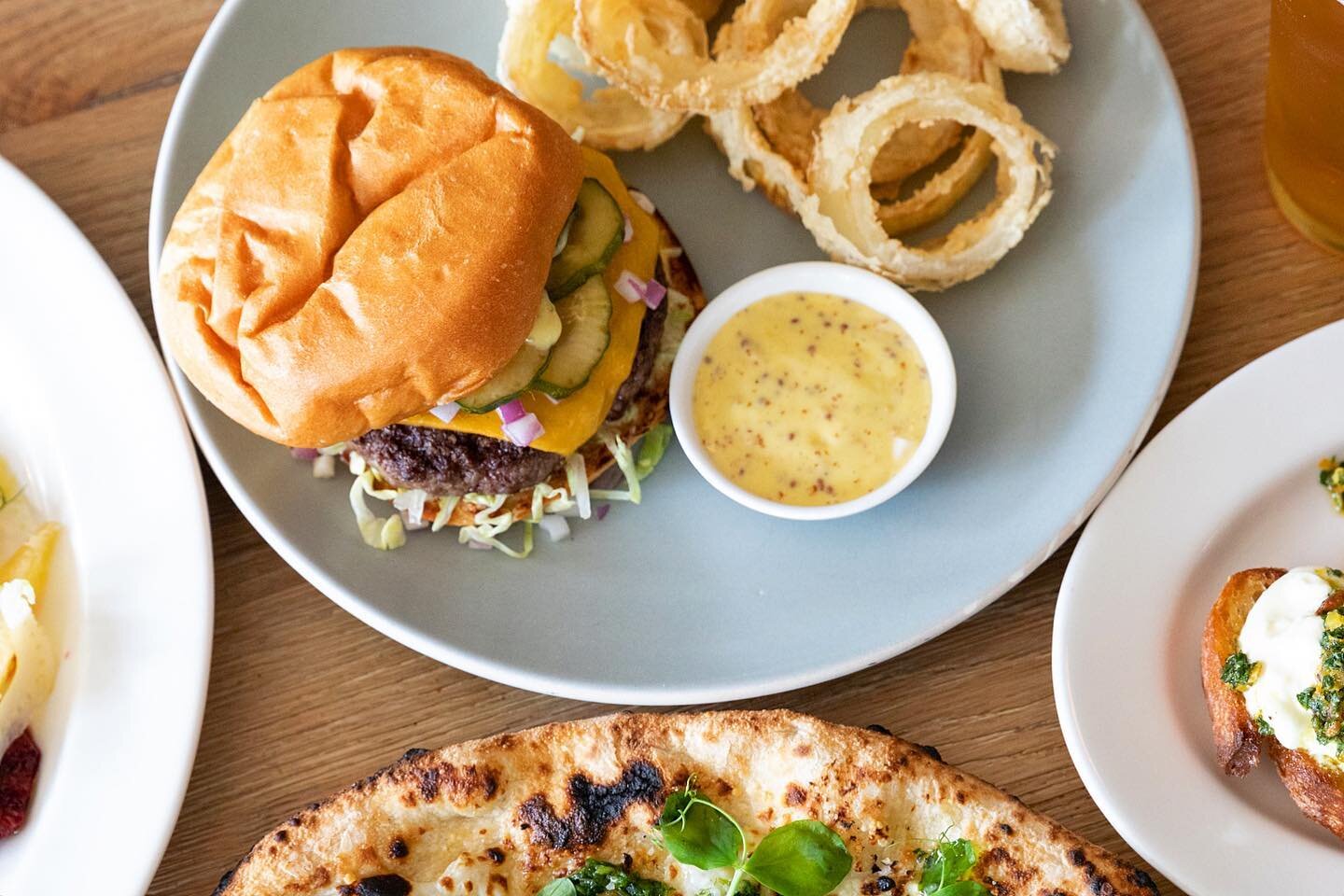 So we meat again... 🍔 It's #BurgerTuesday which means our @flannerybeef burger with onion rings is available for outdoor dining and takeout. 🤤 Come on by to get a taste!