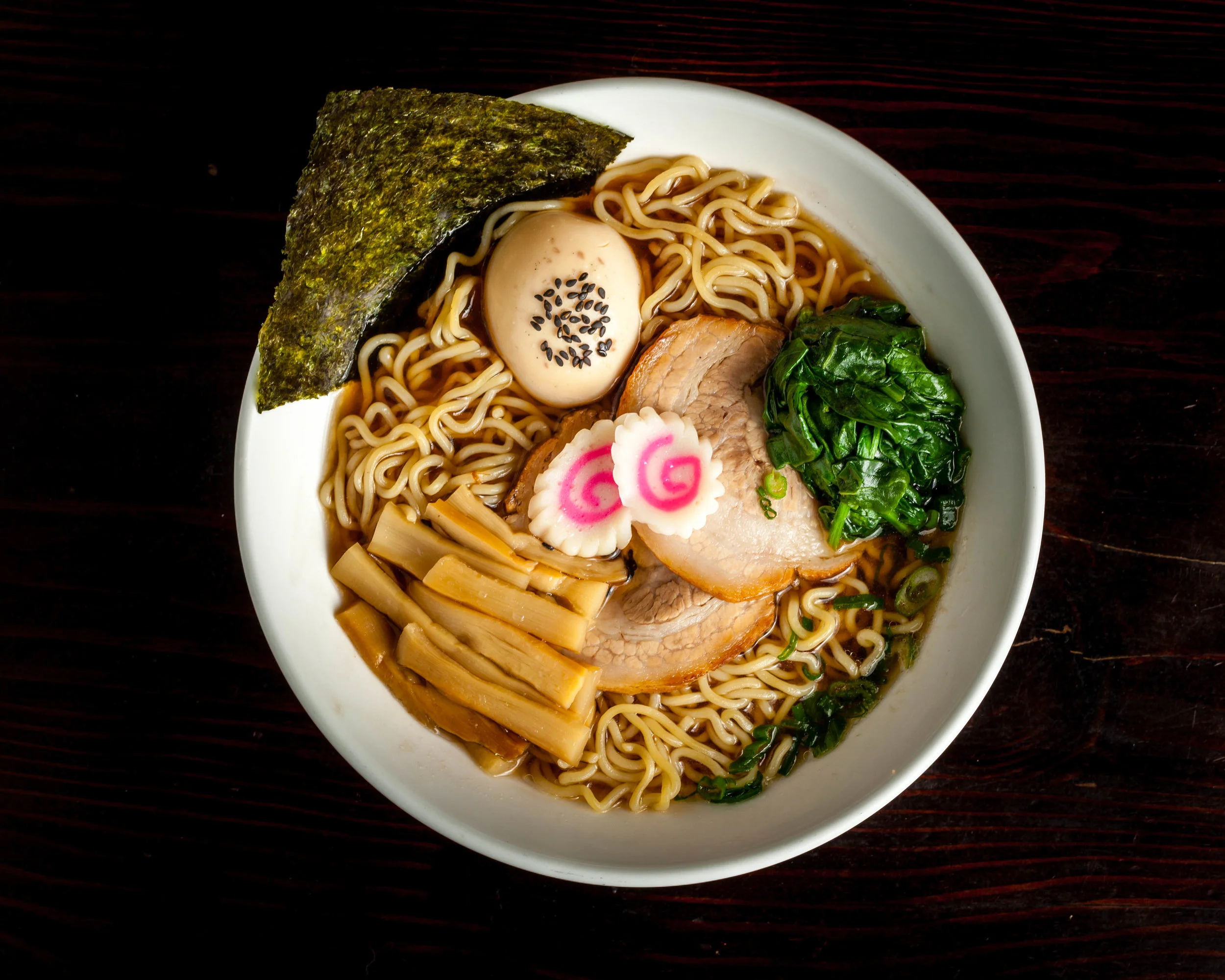 Shoyu Ramen – Lunch $11 Dinner $12.5 soy sauce flavor LIGHT broth (dark brown color), chashu (pork slices), ajitama (marinated soft boiled egg), bamboo shoots, green onion, spinach, naruto fish cake & dry seaweed (Shoyu broth contained: Fish, Wheat, Sesame, Soybean)