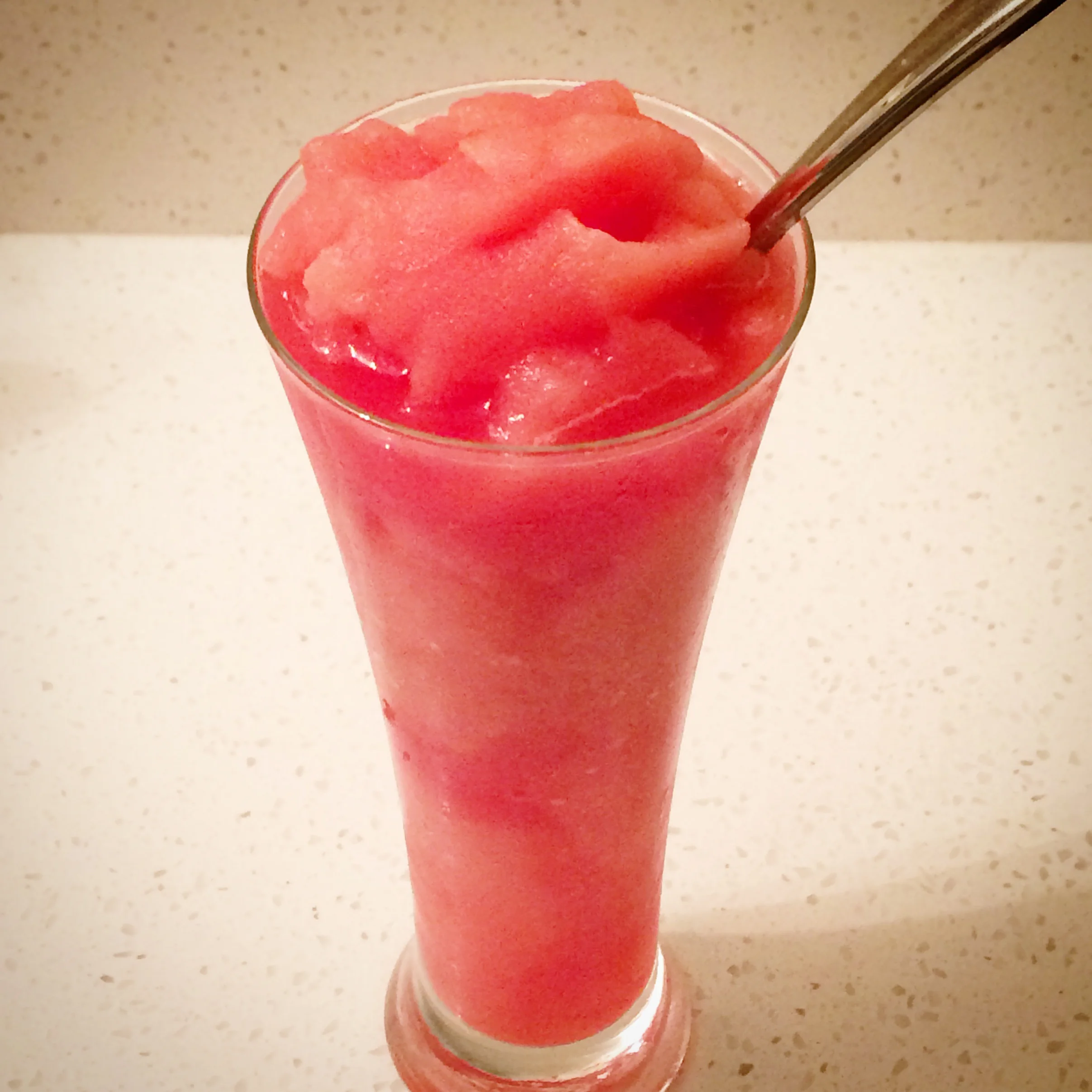 I saw or read a Martha thing a few years ago about cubing watermelon and freezing it on a sheet of parchment on a cookie sheet to make watermelon ice cubes for drinks. Of course I tried it and it was fantastic. Particularly in vodka lemonades (or just lemonades in general). I cubed up a small watermelon a few days ago, and I'm having the annual 'I'm obsessed with summer and watermelon eating' thing . So, Martha whispered in my ear, "let's freeze it, it will be another way we can eat it all the damn time". I left about 1/2 of what was left (maybe 3-4 cups) in the fridge, and laid out the rest in one layer covering the bottom of a metal 9x12 parchment lined baking sheet, and put it in the freezer After work (about 10 hours later), we put the fridge watermelon in the blender and pureed until it was nearly liquified. I added the frozen watermelon cubes in batches, and voila! Watermelon slushes! They were icy, super sweet (almost too much so for me, but I still had no trouble finishing it) and probably about 100 calories (let's not talk about natural sugar). I think this would be great as a cocktail (not sure what would be the proper poison- vodka, rum or tequila), maybe a little basil as well. In the interim, this was way fast and easy and a fantastic hot summer night treat!