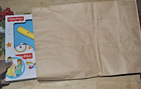 Insert present into brown paper bag