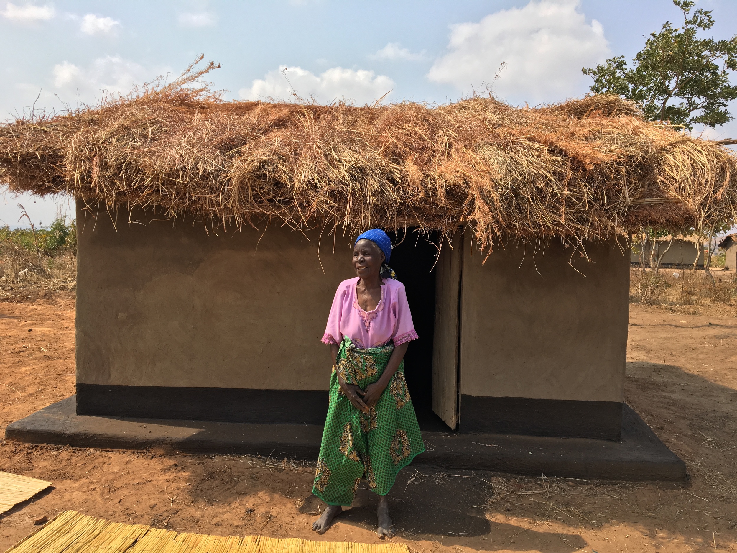 Elizabeth in front of her new home built by World Relief