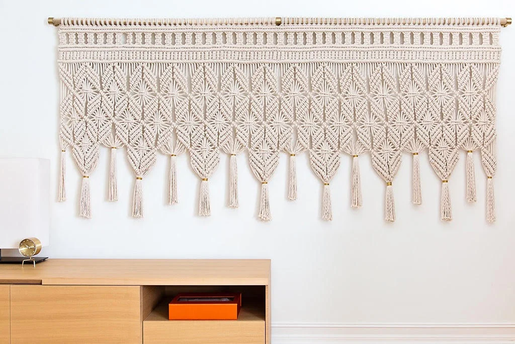 PEACEFUL & REFINED - MACRAME WALL HANGING - 9'W, 4"H THIS DELICATELY KNOTTED DESIGN IS MADE FROM SOFT, NATURAL COTTON CORD AND FINISHED WITH GOLD WRAPPED TASSELS. PERFECT DIEMENSIONS FOR OVER A BED OR A CREDENZA. THIS TEXTURAL PIECE ADDS A RICH LAYER TO ANY SPACE. DIMENSIONS, 9' WIDE, 4' TALL FOR PRICING PLEASE CLICK HERE , FOR ORDERS PLEASE USE THE CONTACT FORM *DESIGNED IN COLLABORATION WITH ROOP RANG INTERIORS AND PHOTOGRAPHED BY GURUSURYA PHOTOGRAPHY