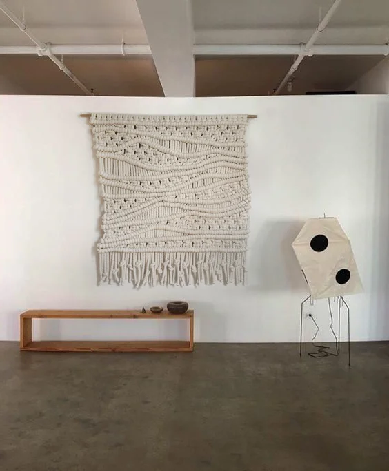 A WABI-SABI FIBER WALL HANGING PERFECT FOR ADDING TEXTURE AND DIMENSION TO ANY SPACE. THIS MACRAME IS MADE WITH OFF-WHITE 100% EXTRA CHUNKY CORD. IT IS KNOTTED BY HAND IN AN ORGANIC STYLE FOR A PIECE THAT FEELS DYNAMIC AND RELAXED. DIMENSIONS: 6' WIDE X 6' HIGH FOR PRICING CLICK HERE , FOR ORDERS PLEASE USE THE CONTACT FORM
