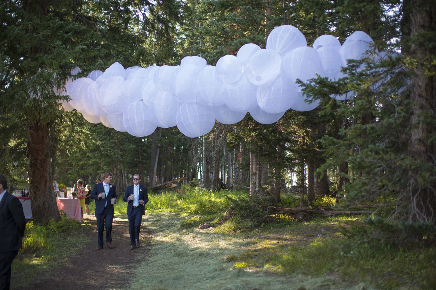 VAN WYCK Clusters of lanterns among trees welcome guests at a mountaintop wedding in Vail.