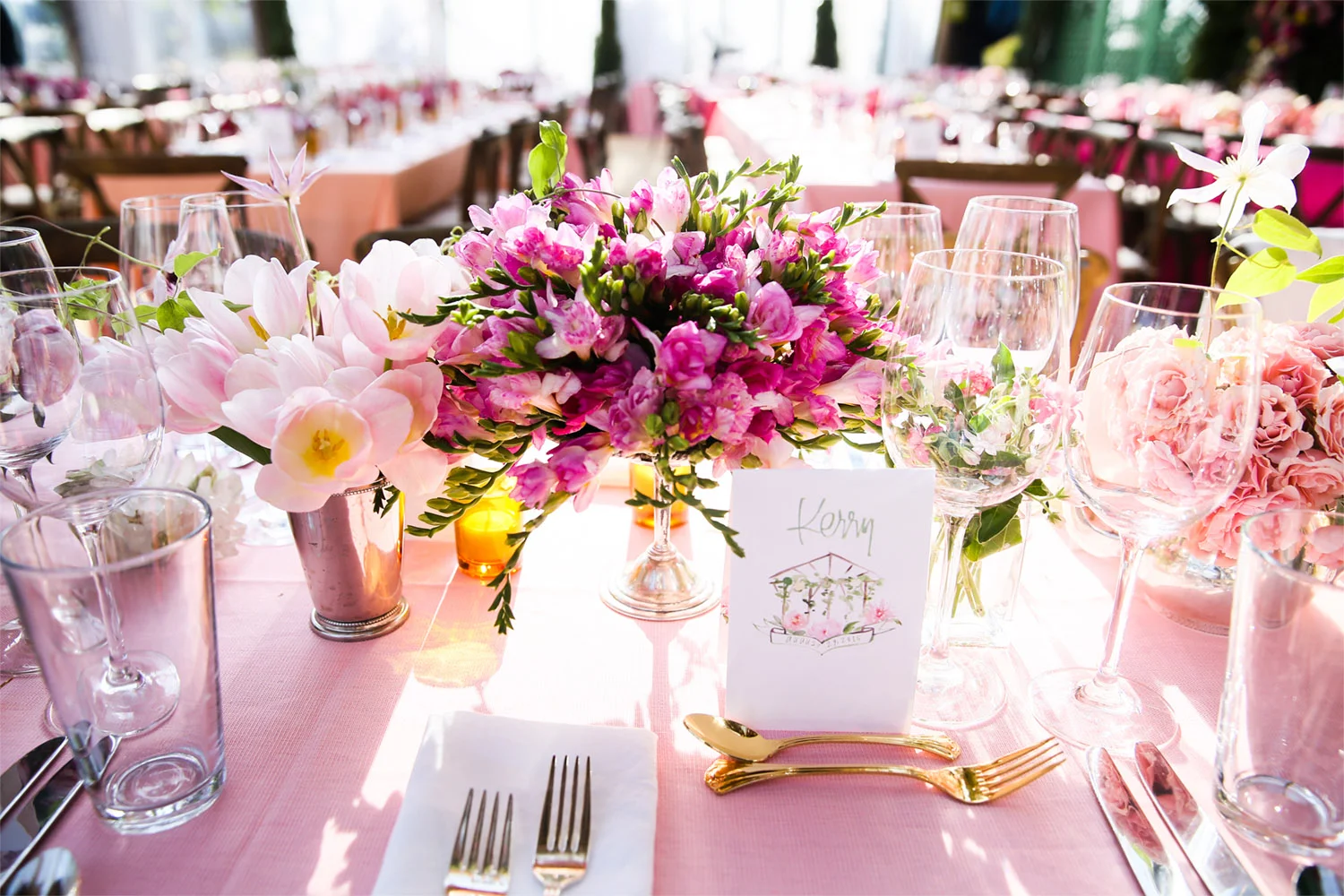 VAN WYCK The tables are set for dinner with shades of pink and watercolor menus at a mountaintop wedding in Vail.