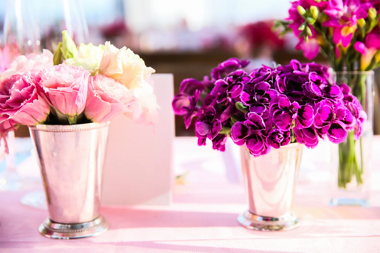 VAN WYCK Pink flowers in antique julep cups line the tables at a mountaintop wedding in Vail, CO.