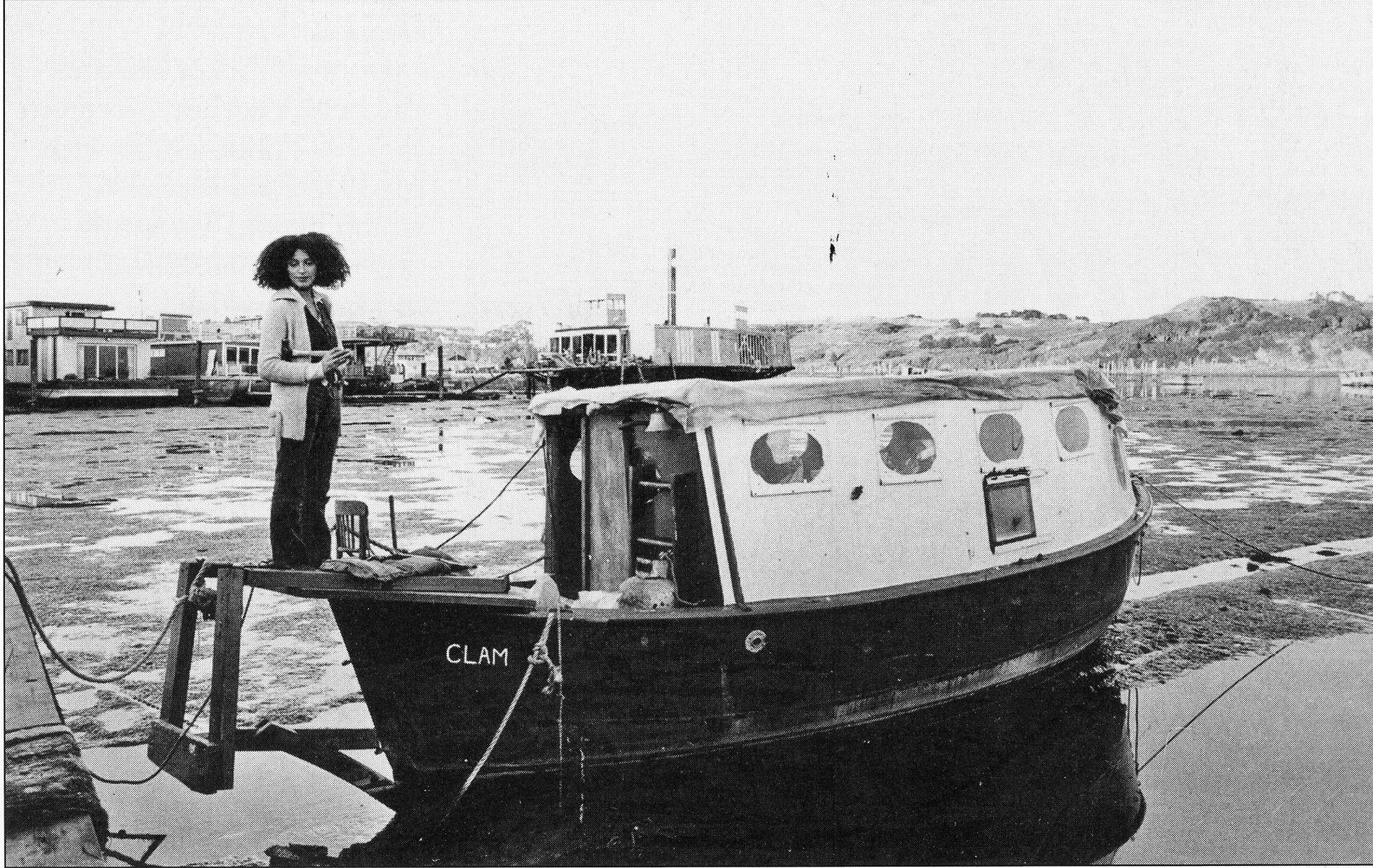 A tiny floating home perched atop a landing craft.