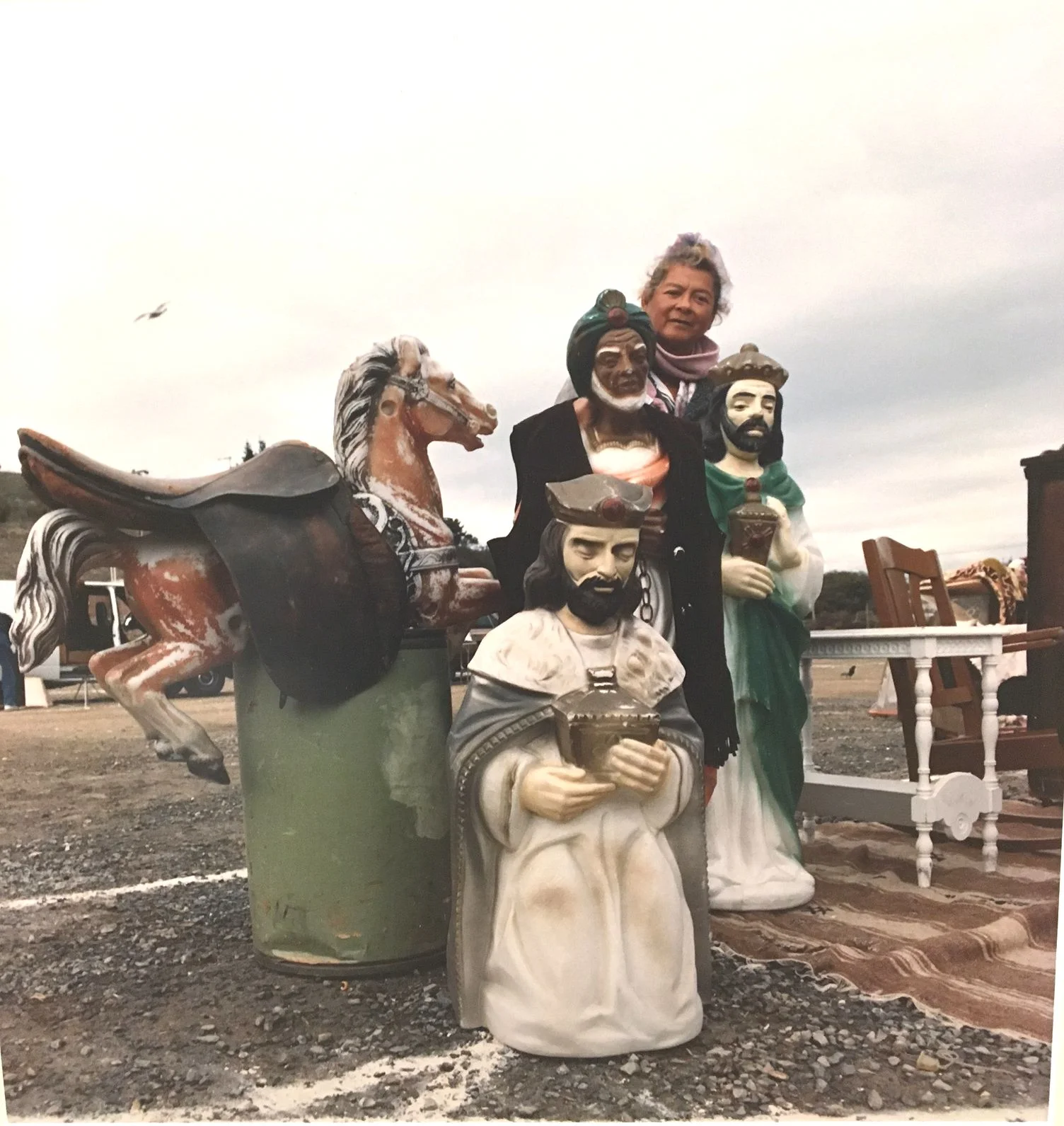 Flea market vendor surrounded by statues. Photo by Nancy Kittle, courtesy of Anne T. Kent California Room, Marin County Free Library