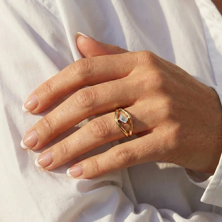 Model wearing a 14K yellow gold emerald cut diamond ring with sculptural band and single 0.34 ct. diamond. (Copy)