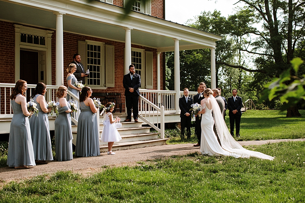  Charming wedding ceremony outside the manor house at Locust Grove in Louisville Kentucky. spring wedding ceremony Locust Grove Louisville photographer Kentucky wedding photography by Lauren outdoor wedding dress bride and groom black suit flower gir