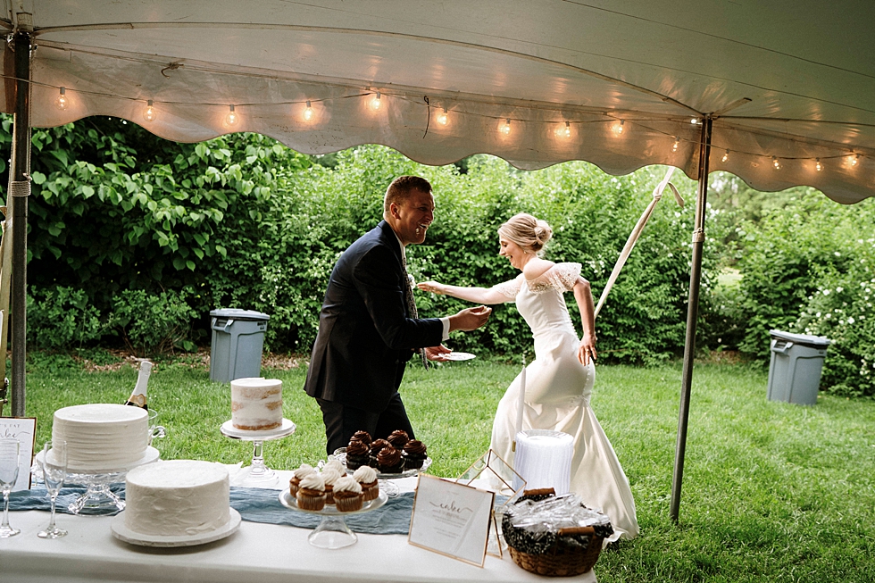  Groom moments after cake smashed into his face by his playful bride at this outdoor wedding reception in Louisville Kentucky. spring wedding dress Locust Grove Louisville photographer Kentucky wedding photography by Lauren outdoor wedding cake fight