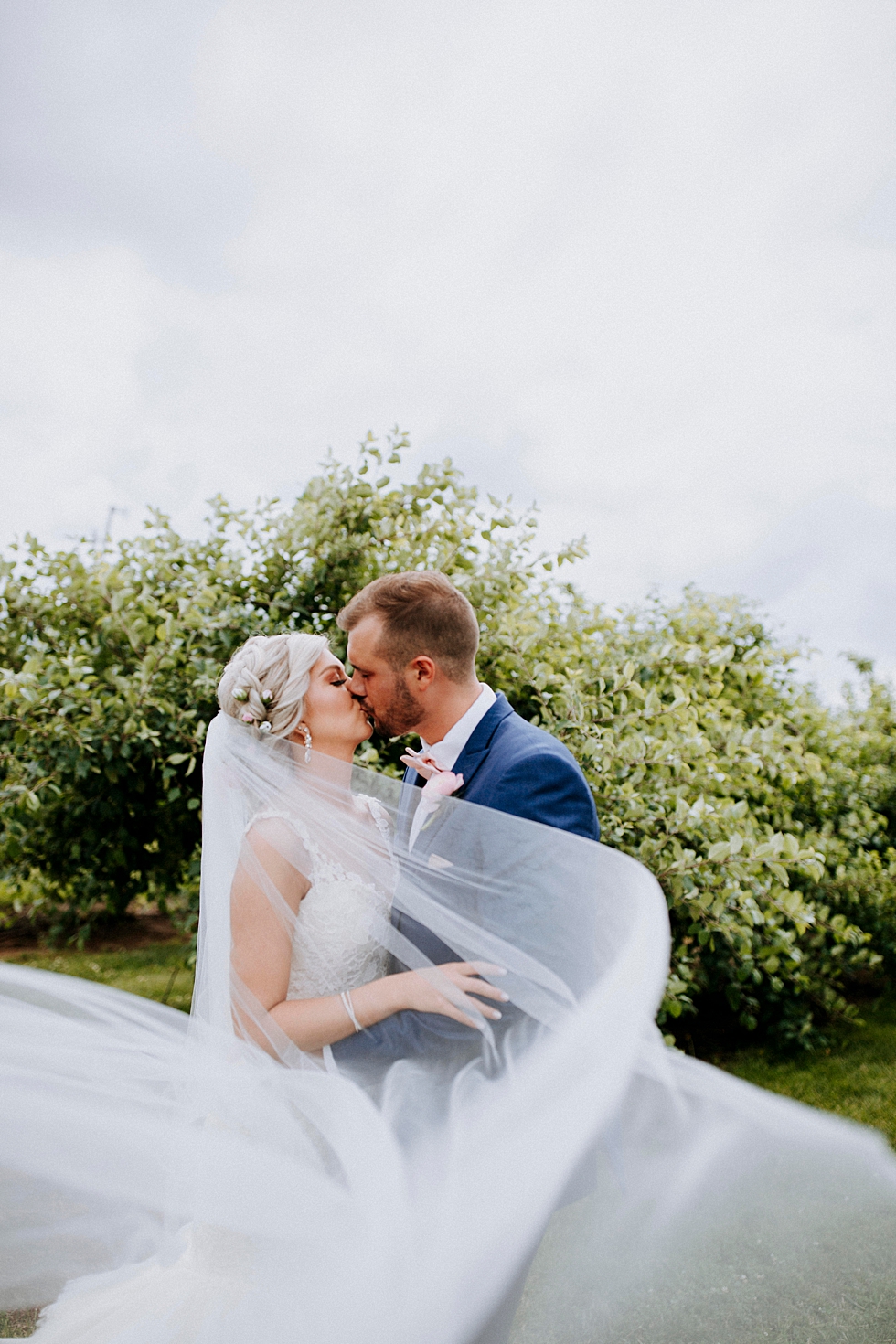  Sweet embrace at this charming southern wedding at Huber’s orchard and winery in Louisville Kentucky. Huber’s orchard and winery spring wedding Louisville Kentucky wedding photography by Lauren outdoor wedding ceremony bride and groom kiss flow wedd