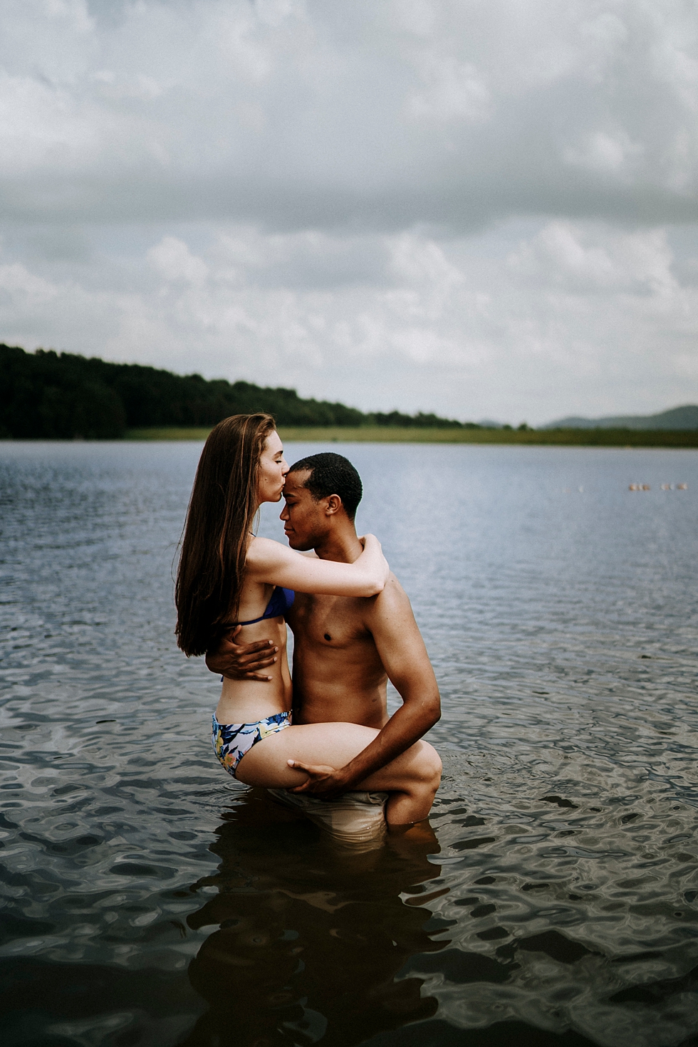  groom to be holding the bride to be in deam lake swim suits kiss on the forehead engagement session kentucky engagement photographer #engagementphotographer #louisvilleengagementphotographer #kentuckyengagmentphotographer #kentuckyengagments #engage