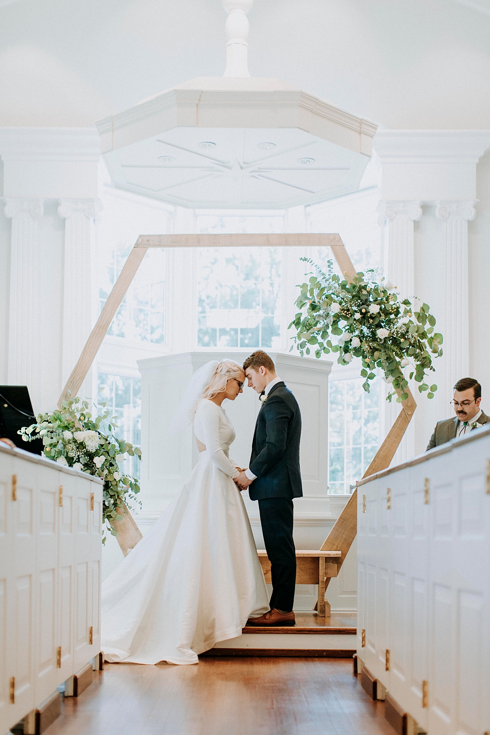  Exchanging of vows and wedding ceremony with wooden arch with floral accents bride and groom precious moment #weddingphotographer #broaduschapel #weddingdaybliss #louisvillephotographer #kentuckyweddingphotographer #weddingsession #photographyanddes