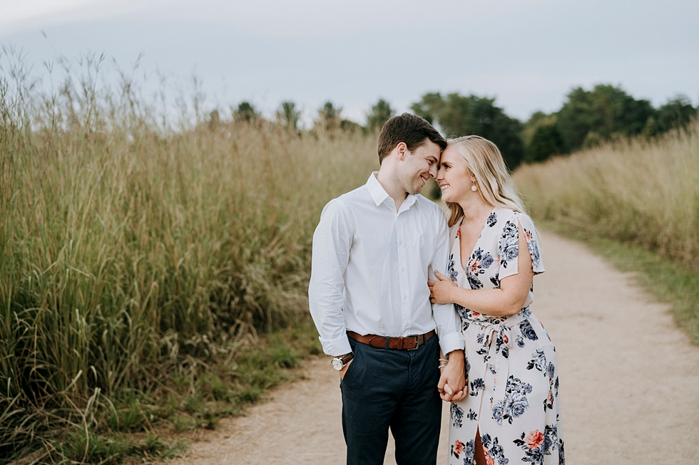  Engaged couple walking side by side on forest pathway with heads together looking into each others eyes #engagementphotographer #bernheimforest #engagementgoals #kentuckyengagementphotographer #kentuckyphotographer #engagementsession #photographyand