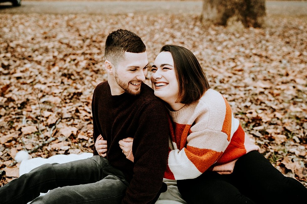  Engaged couple sitting on the ground surrounded by fall leaves, laughing together. #engagementgoals #engagementphotographer #engaged #outdoorengagement #kentuckyphotographer #indianaphotographer #louisvillephotographer #engagementphotos #savethedate