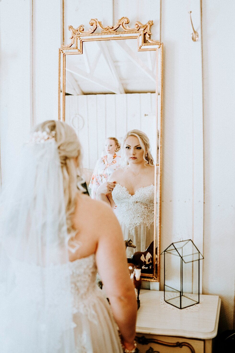  Beautiful bride putting on the final touchese before she becomes a married woman. western wedding midway kentucky vintage barn gold mirror lace wedding gown sweetheart neckline #vintagebarn #westernwedding #midwayky #vintagewedding #horses #thatsdar