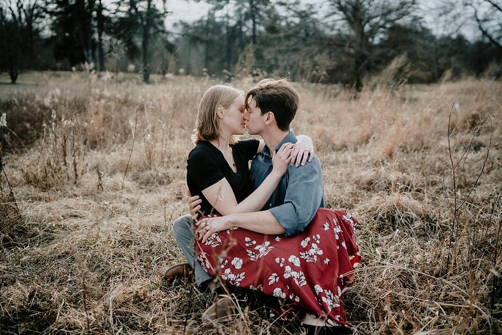  This love struck fellow couldn’t let his future bride to be go as they shared a kiss during their Louisville, Kentucky engagement session. Kentucky mountains red floral skirt dark black shirt cloudy skies engagement session Photography by Lauren out