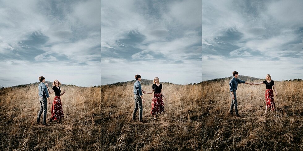  Love was blossoming despite this cloudy day for this couple who couldn’t wait to celebrate and share the news of their engagement. Kentucky mountains red floral skirt dark black shirt cloudy skies engagement session Photography by Lauren outdoor #ph