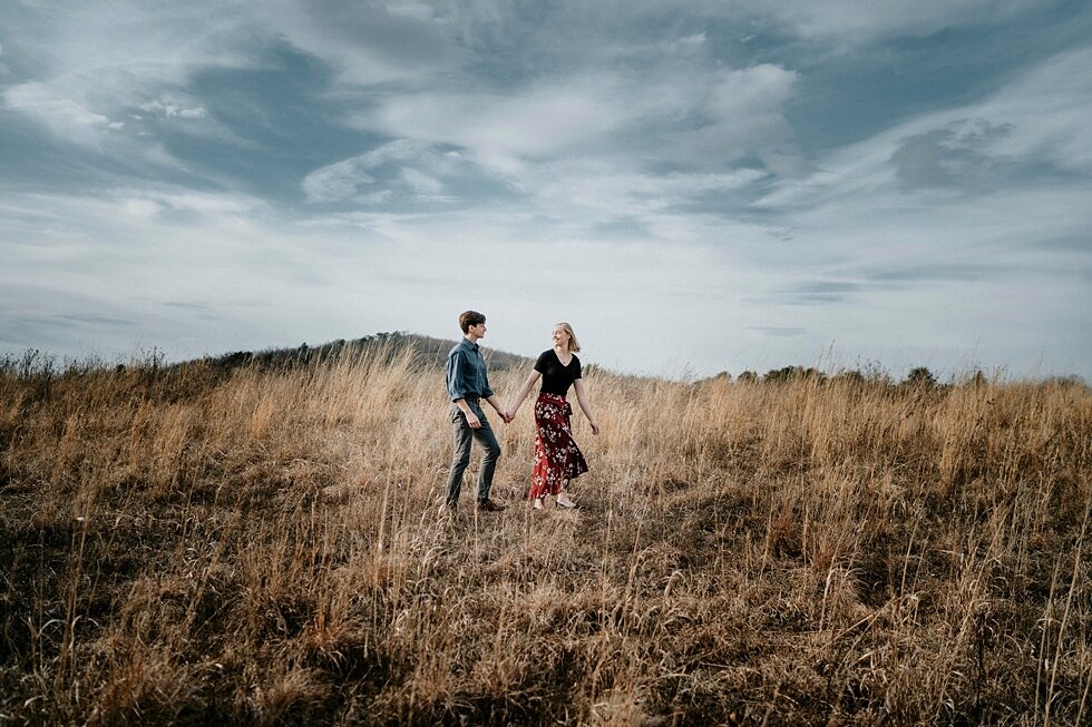  Engagement session in Louisville, Kentucky with the Kentucky mountains in the background. Kentucky mountains red floral skirt dark black shirt cloudy skies engagement session Photography by Lauren outdoor #photographybylauren #kentuckyengagementphot