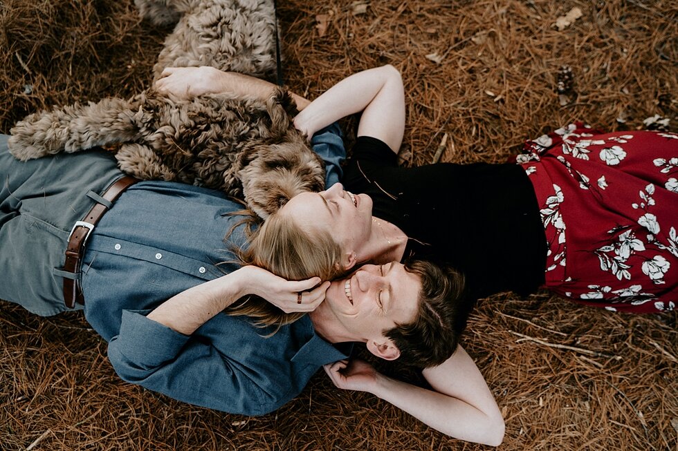  This couple is creating a family of three that includes their furry family member. Kentucky mountains red floral skirt dark black shirt cloudy skies engagement session Photography by Lauren outdoor #photographybylauren #kentuckyengagementphotography