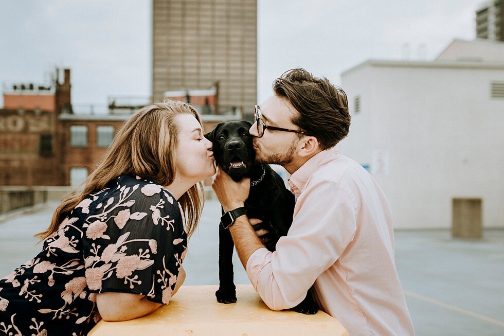 Kisses for the engaged couple and their black dog during their rooftop engagement session in Louisville, Kentucky. getting married outdoor session engaged couple together wedding preparation love excited stunning relationship #engagementphotos #midw