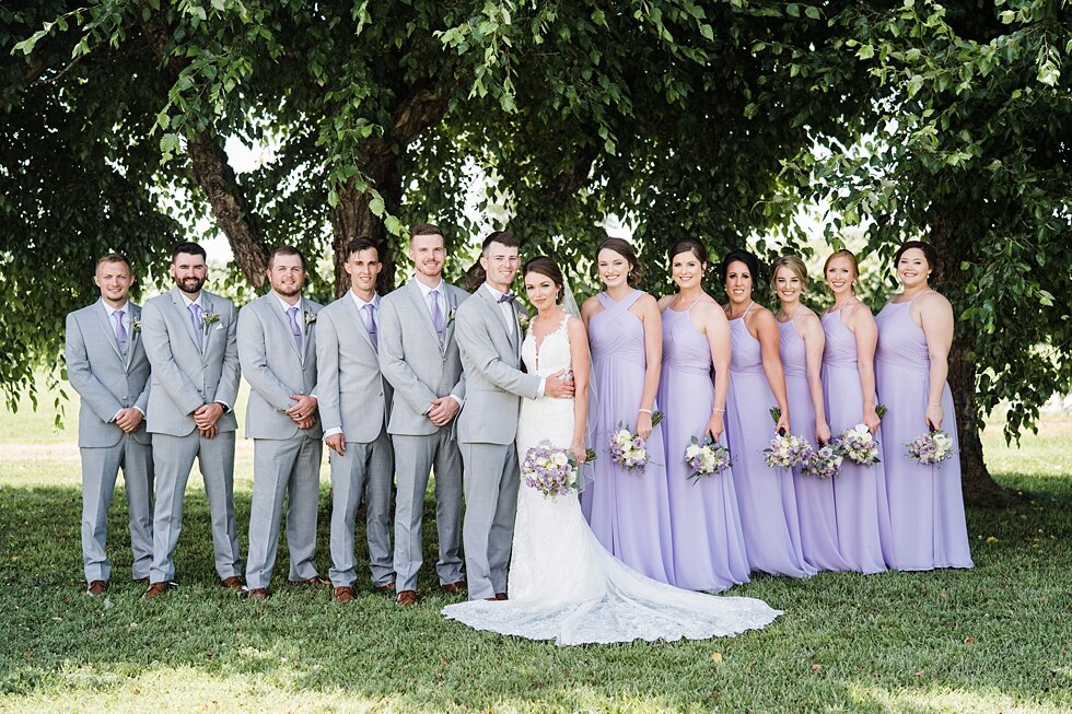  Wedding party at hubers winery on wedding day with bridesmaids in purple dresses and the groomsmen wearing grey suits like the groom. #thatsdarling #weddingday #weddinginspiration #weddingphoto #love #justmarried #midwestphotographer #kywedding #lou