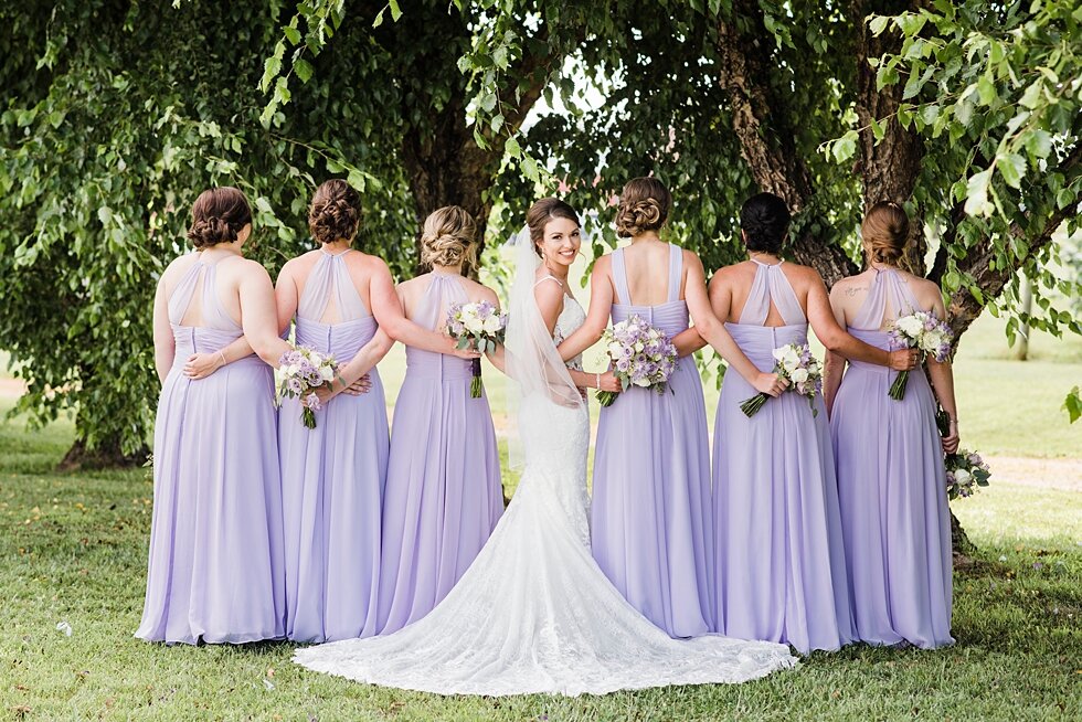  Bride smiling at the camera while bridal party is faced backwards. wedding ceremony details stunning photography married midwest louisville kentucky #weddingphoto #love #justmarried #midwestphotographer #kywedding #louisville #kentuckywedding #aubur
