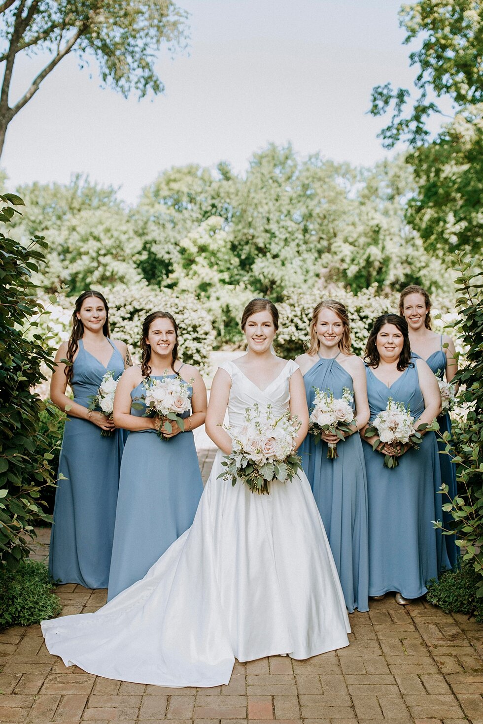  bride and bridesmaids with bouquets wearing blue dresses in garden  #thatsdarling #weddingday #weddinginspiration #weddingphoto #love #justmarried #midwestphotographer #kywedding #louisville #kentuckywedding #louisvillekyweddingphotographer #wedding
