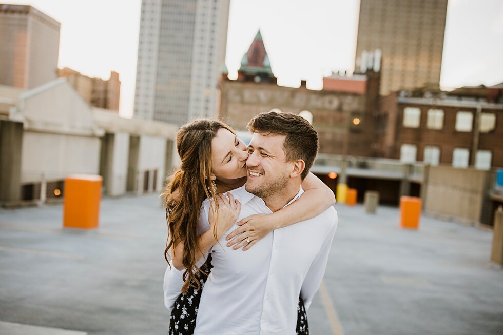 Kiss on the cheek on urban roof top in Kentucky. Louisville photographer engagements urban roof top anniversary romantic kentucky candles love #engagementphotos #savethedatephotos #savethedates #engagementphotography  #StJamesCourt #gardenengagment 
