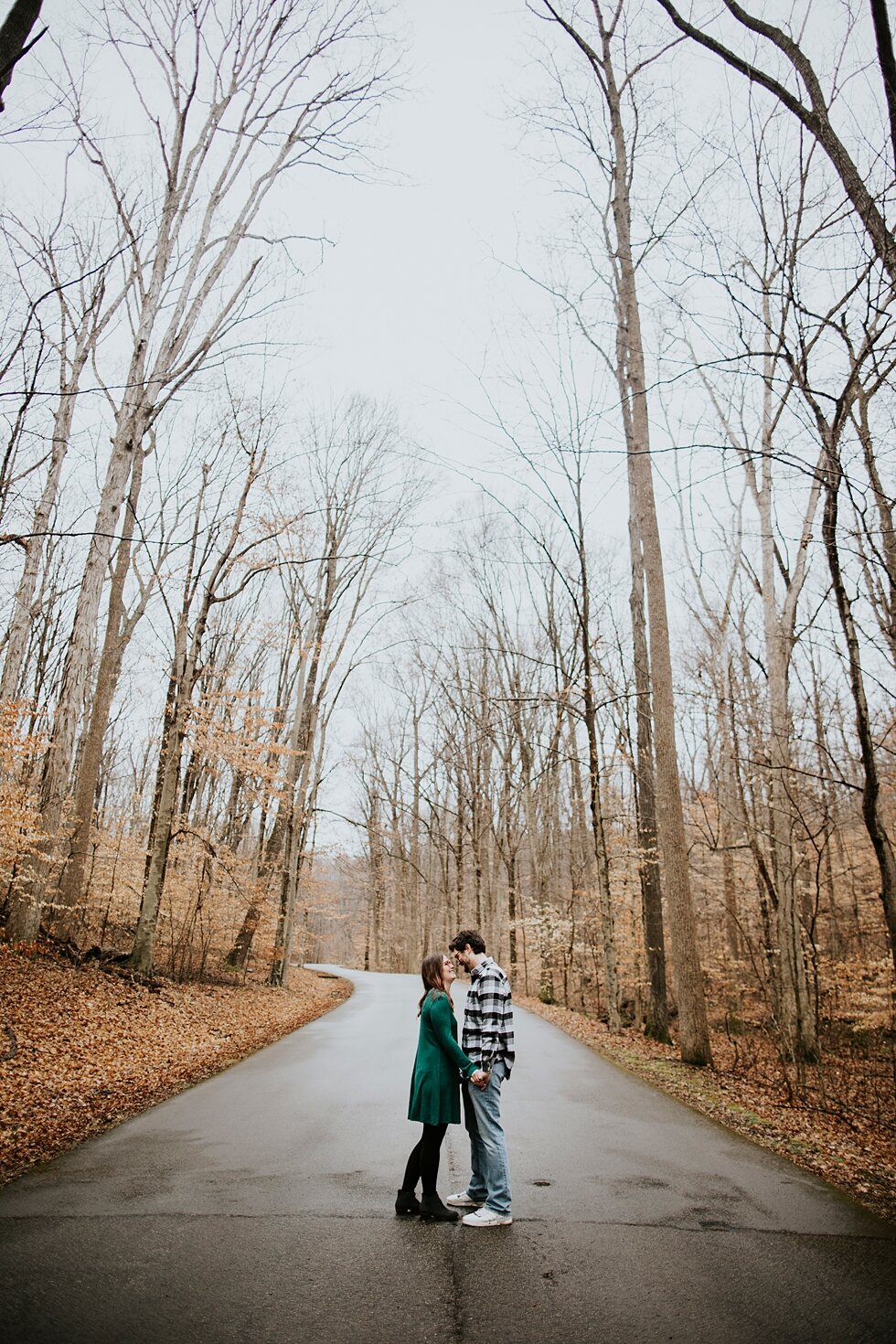  Rainy path leading this engaged couple down the road in Bernheim Forest in Louisville, Kentucky. Louisville photographer winter engagement Bernheim Forest emerald green dress plaid shirt rainy day Kentucky couple outdoor engagement  #savethedates #e