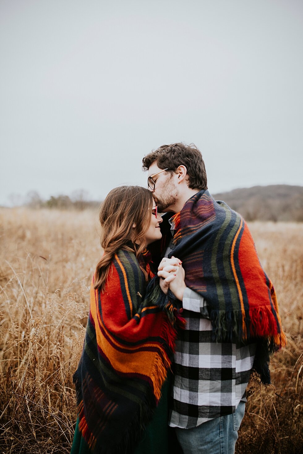  Beautiful blanket joining this man and woman together during their engagement session and save the date photo shoot just outside the Bernheim Forest in a clearing. Louisville photographer winter engagement Bernheim Forest emerald green dress plaid s