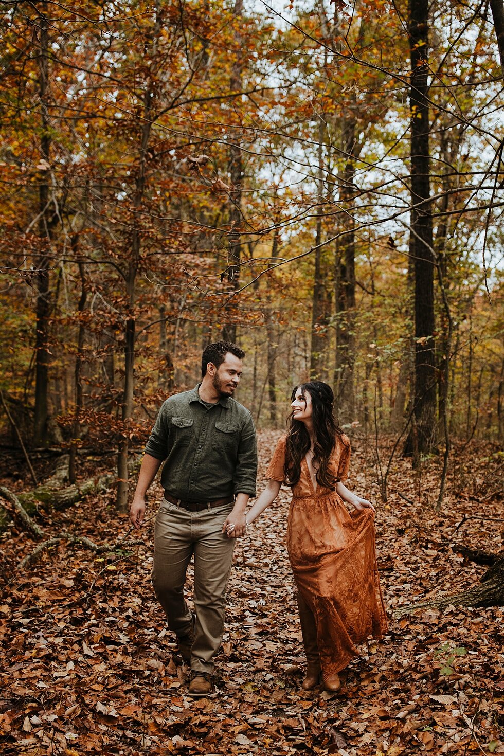  Stunning fall engagement photo shoot capturing rustic orange and yellow leaves in the tall wooded area of Bernheim Forest complemented by the bride to be in a gorgeous orange dress. fall photography midwest kentucky engagement save the dates crisp f