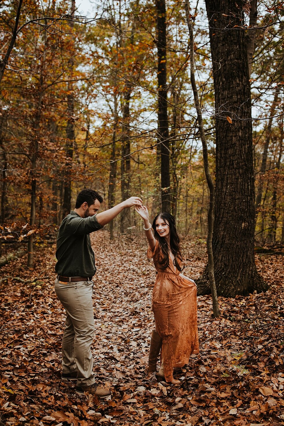  Dancing through the tall Bernheim Forest enjoying all the Kentucky charm that fall has to offer during their save the date session. engagement goals kentucky photographer outdoor engagement indiana photographer fall photo shoot orange and yellow col
