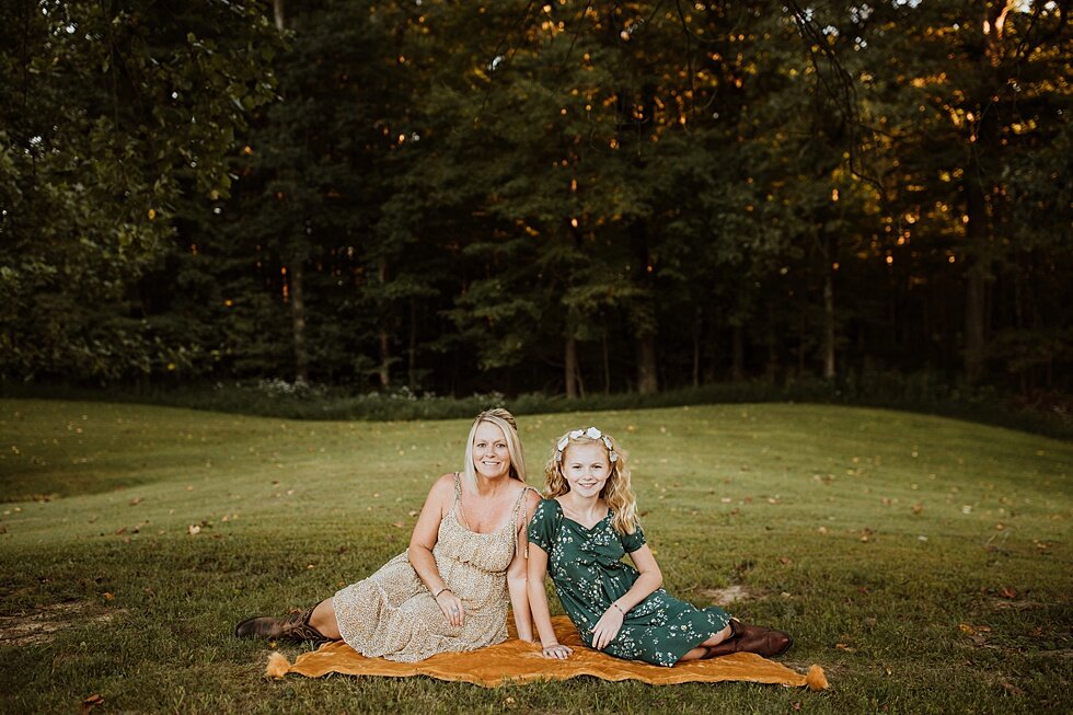  Both mother and daughter sitting together on a blanket in their farm yard with nothing surrounding them and no distraction from their bond and relationship with each other. Fall Louisville Kentucky photographer mother daughter photography session po