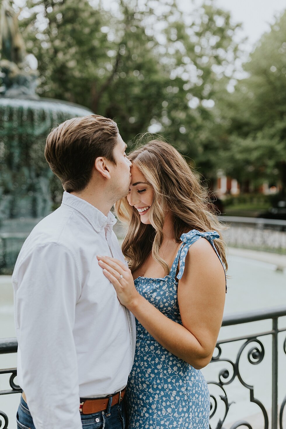  Sweet kiss on the forehead as this engaged couple shared their engagement shoot in front of the beautiful St James Court water fountains. #engagementphotos #savethedatephotos #savethedates #engagementphotography  #StJamesCourt #gardenengagment   #ce