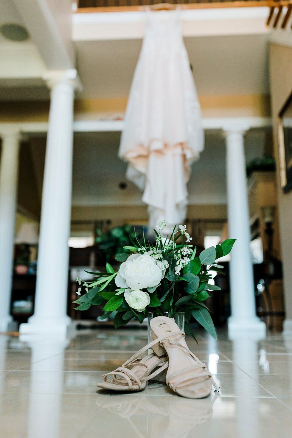  Wedding dress complete with bridal bouquet and wedding shoes for the bride to wear down the aisle on her special day. Romantic casual lace wedding gown close friends neutral colors background wedding natural greenery crisp white #midwestphotographer