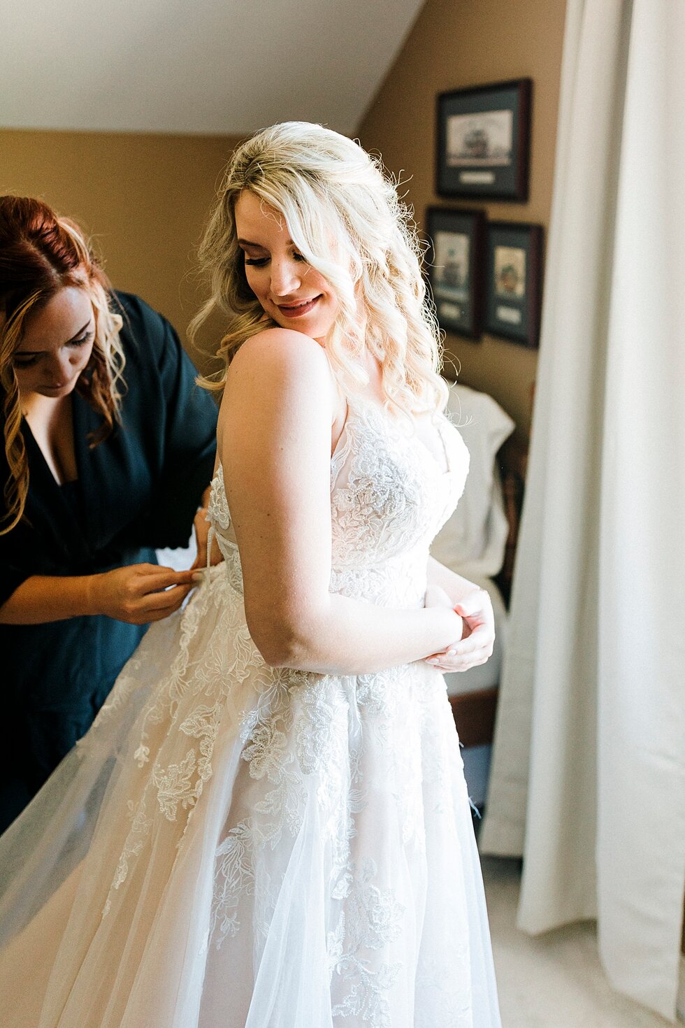  Adding the finishing touches as this beautiful bride prepares to walk down the aisle on her wedding day! Romantic casual lace wedding gown close friends neutral colors background wedding natural greenery crisp white #midwestphotographer #kywedding #