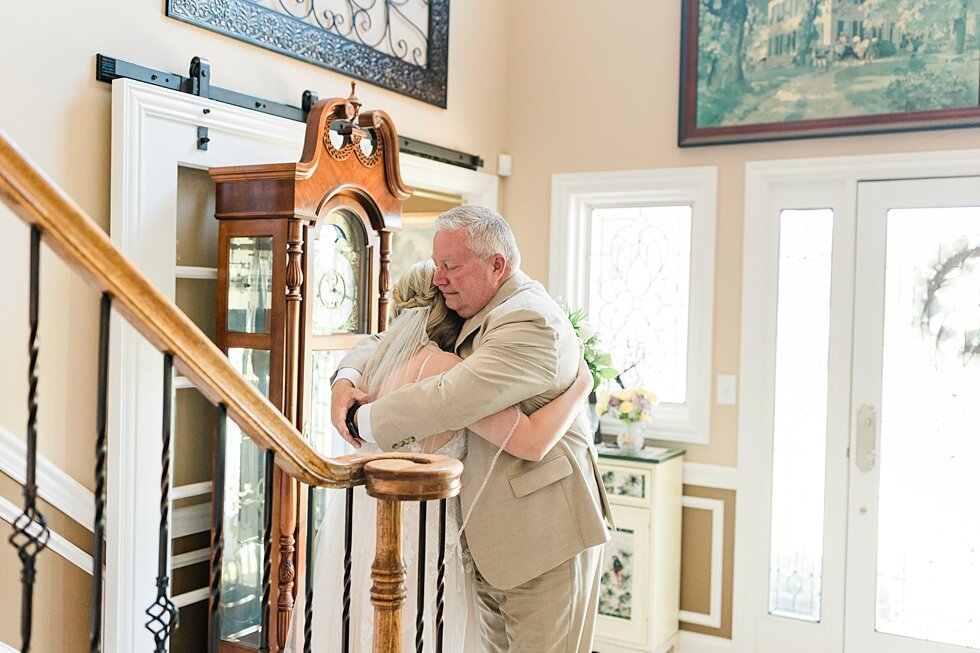  Such a tender moment between the father of the bride and the bride herself as she reached the bottom of the staircase and was able to give her dad a hug. Romantic casual lace wedding gown close friends neutral colors background wedding natural green