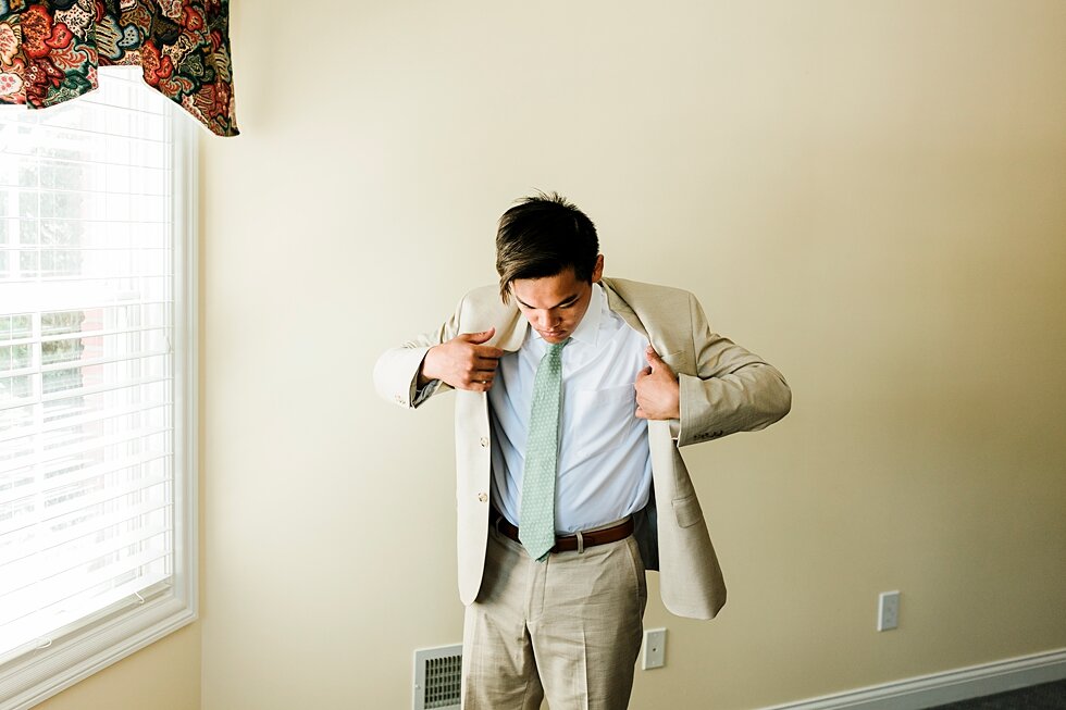  Getting his jacket on was the final touch to his outfit that let him complete getting ready. Romantic casual lace wedding gown close friends neutral colors background wedding natural greenery crisp white #midwestphotographer #kywedding #louisville #