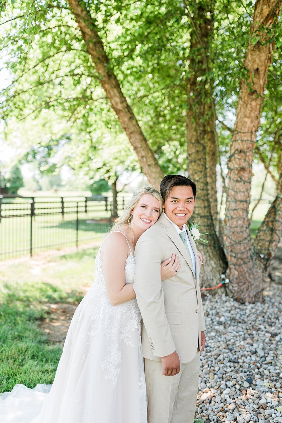  Such a wonderful couple taking portraits after they tied the knot during their romantic and intimate backyard wedding! Romantic casual lace wedding gown close friends neutral colors background wedding natural greenery crisp white #midwestphotographe