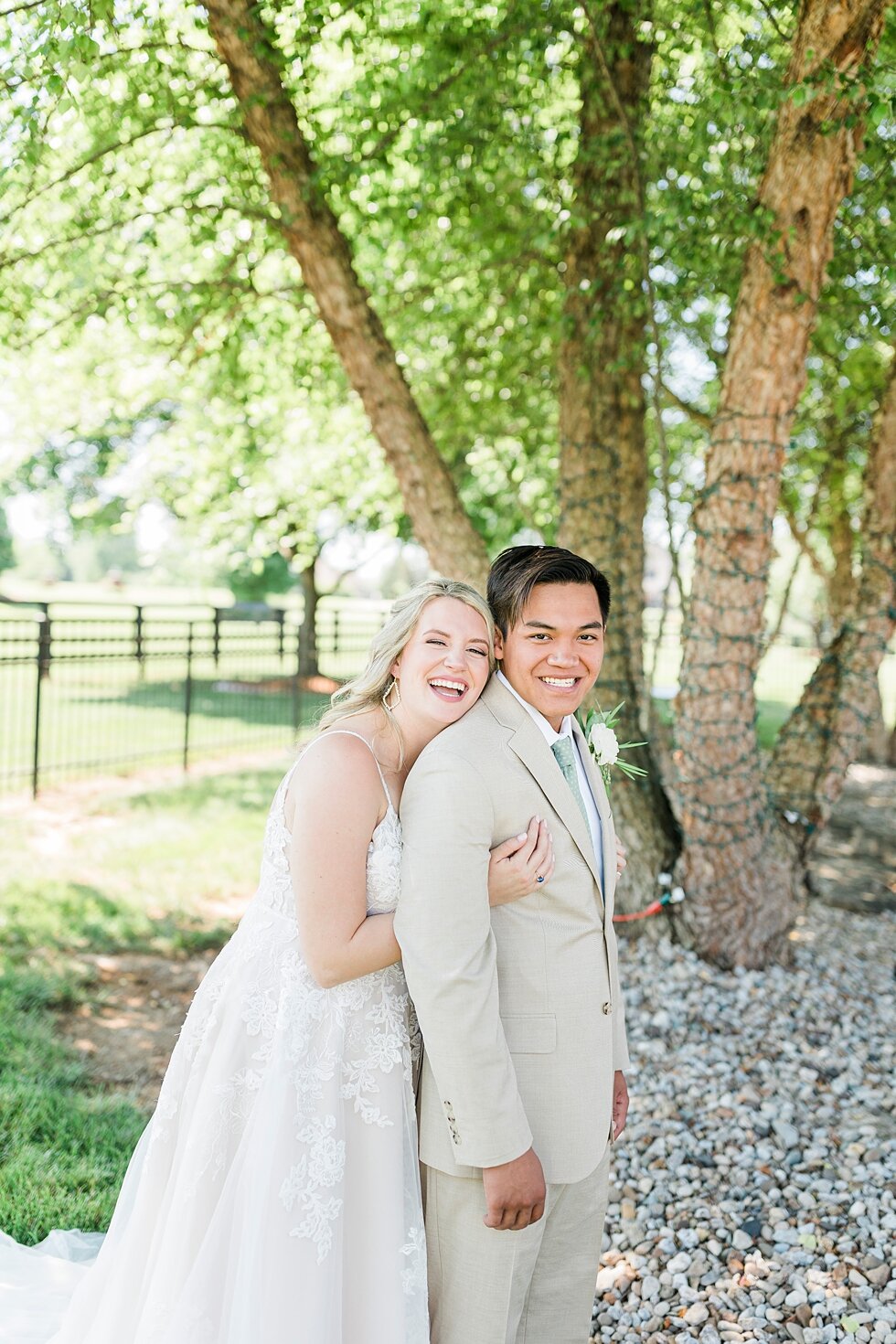  Such a wonderful couple taking portraits after they tied the knot during their romantic and intimate backyard wedding! Romantic casual lace wedding gown close friends neutral colors background wedding natural greenery crisp white #midwestphotographe